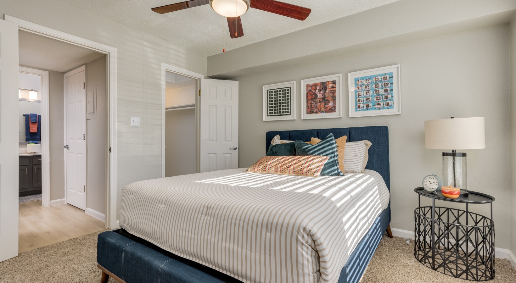 a bedroom with a bed, dresser and ceiling fan at The Winslow
